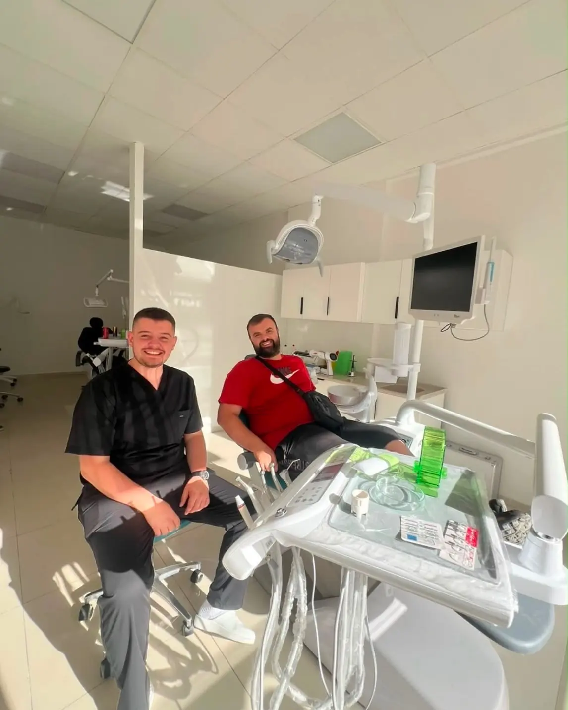Dy persona duke buzëqeshur brenda një dhome trajtimi në Smile Line